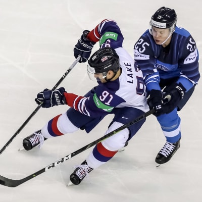 Två hockeyspelare i kamp om pucken.