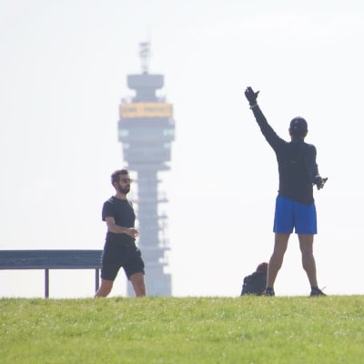 Kaksi lenkkeilijää taustallaan BT Tower -tietoliikennetorni.