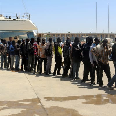 Afrikanska flyktingar som räddats från en sjunkande båt fördes tillbaka till Tripoli i Libyen.