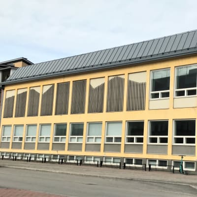 Kaksikerroksinen, keltapunainen entinen koulurakennus Joensuun Yläsatamakadun varressa. 