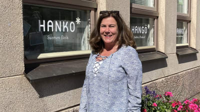 Kvinna står vid ett hus
