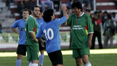 Diego Maradona och Bolivias tidigare president Evo Morales hälas på varandra under en fotbollsmatch