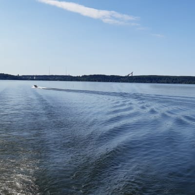 Vene ajaa Vesijärvellä, horisontissa näkyy Lahden hyppyrimäki