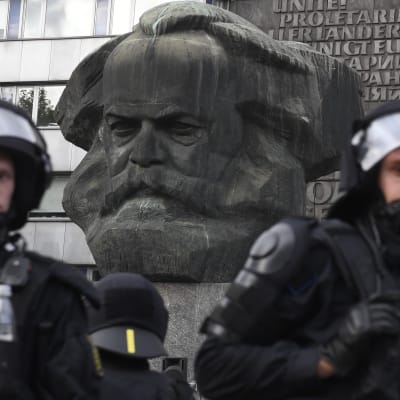 Chemnitzissä poliiseja Karl Marxin patsaalla, jonka vieressä mielenosoittajat kokoontuivat.