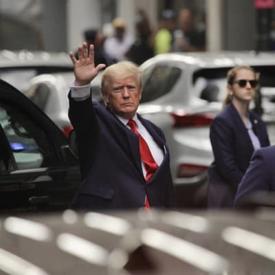 Donald Trump håller upp handen som om han skulle vinka.
