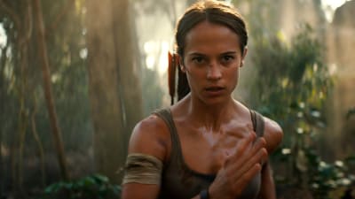 Lara Croft springer rakt mot kameran i djungelmiljö.
