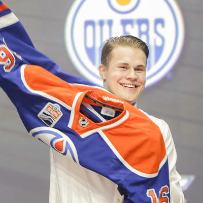 En glad Jesse Puljujärvi drar på sig Edmontontröjan i samband med draften 2016.