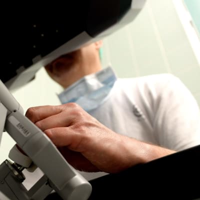 Kirurg avlägsnar metastaser i sköldkörteloperation, assisterad av robot