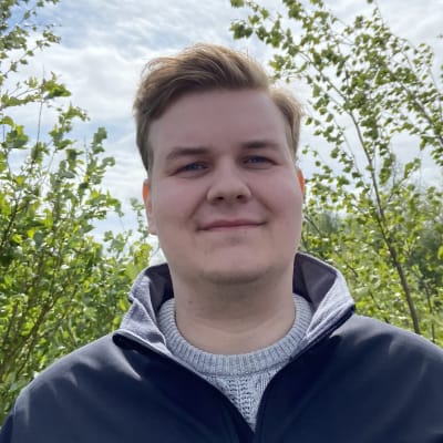Konsta Huhtala seisoo luonnossa puiden keskellä