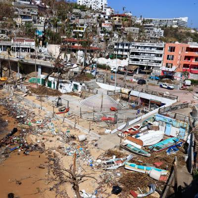 Båtar och skräp ligger huller om buller på en strand i Acapulco i Mexiko efter en kraftig storm.