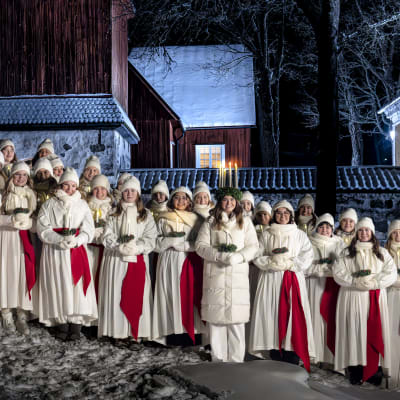 Finlands lucia 2023 Madeleine Amoroso står uppställd utomhus med sina tärnor står i ett snöigt Fagervik i Ingå. 