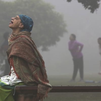 En kvinna utövar yoga i ett luftförorenad New Delhi.