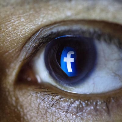 Ett öga med en spegling av Facebooks logo i irisen.