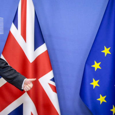 Storbritanniens premiärminister Boris Johnson och EU-kommissionens ordförande Ursula von der Leyen tittar mot varandra. Johnson står framför Storbritanniens flagga, von der Leyen framför EU:s flagga. Johnson visar tummen upp. Bilden tagen 9.12.2020.