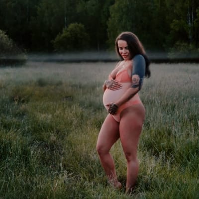 Pernilla Backman på en äng med gravidmage