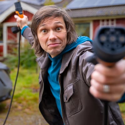 Johan Gullmets håller i en kabel för att ladda elbil.