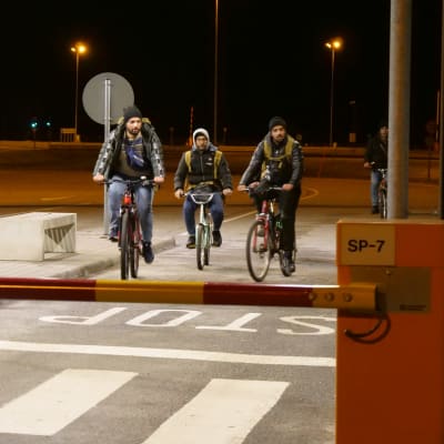 Kolme polkupyörällä Nuijamaan raja-asemalle Venäjältä saapuvaa turvapaikanhakijaa puomin takana.