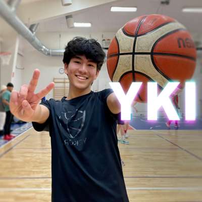 Hymyilevä nuorimies pitää kädessään koripalloa ja toisella kädellä näyttää peace-merkkiä, kuvan päällä YKI-teksti.