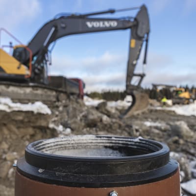 Kaivinkoneet kaivavat putkia maahan.