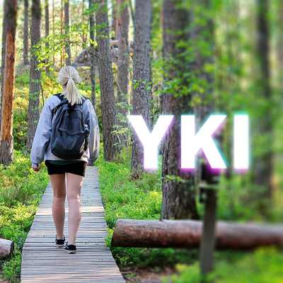 Nainen kävelee metsässä pitkospuilla, kuvan päällä on YKI-teksti.