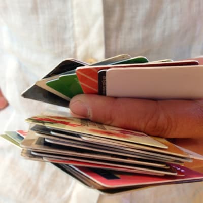 Etukortteja ja muita lompakosta löytyneitä kortteja kädessä.