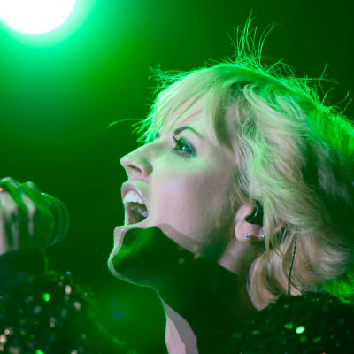 Dolores O’Riordan sjunger i en mikrofon som hon håller i handen.