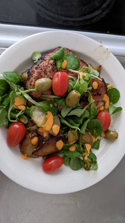 Kött med tomat, oliver och sallad.