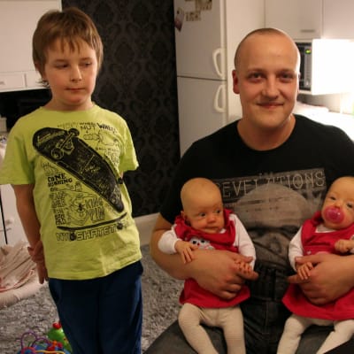 Keskosvauvat Ilona (vas.) ja Taika isänsä Perttu Paavilaisen sylissä isoveli Akselin valvovan silmän alla.