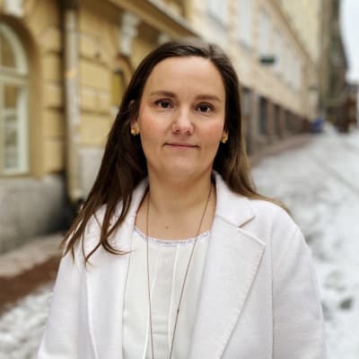 Linda Flander står på en gata en grå vinterdag.