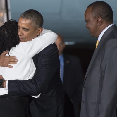 Obama möts av sin halvsyster Auma Obama och president Uhuru Kenyatta på Nairobis flygfält, Kenya.