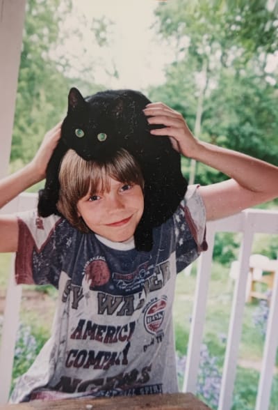 Nuori Emil Kihlström mustan kissansa kanssa.