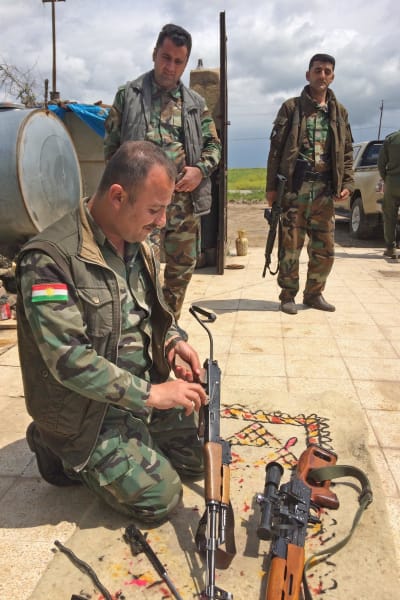 Kurdiska soldater gör vapenvård. Gränsen mot regeringskontrollerat område går ett tjugotal kilometer söderut