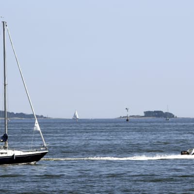 En segelbåt och en motorbåt på havet.