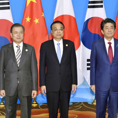 På bilden står Sydkoreas president  Moon Jae-in, Kinas premiärminster Li Keqiang och Japans premiärminister Shinzo Abe på rad.