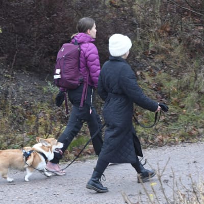 Två kvinnor på promenad med hund. 