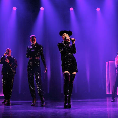 A cappella-gruppen Fork på scenen i svarta kläder och lila scenljus.