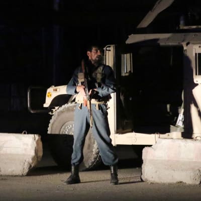 Afghansk polis säkrar en väg i Kabul efter bombdåd.