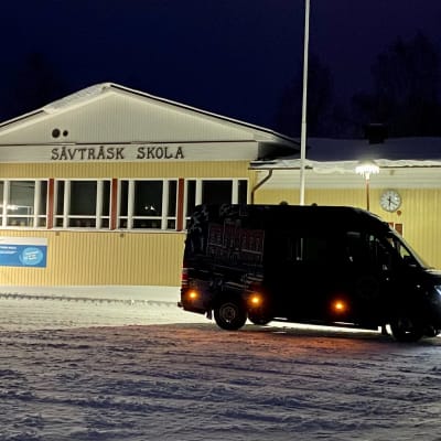 Ungdomsbilen står på en snöig skolgård.