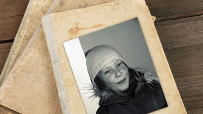 Svartvitt fotografi på Rosanna Fellman som elvaåring med vit vintermössa.