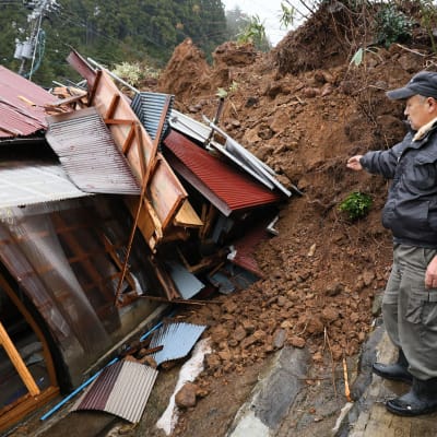 En man tittar på sitt hem som krossats av jordskalv i staden Anamizu i prefekturen Ishikawa den 3 januari 2024