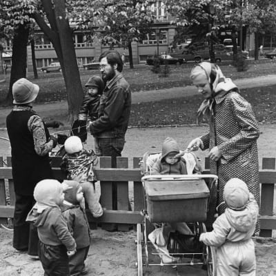 Puistotäti hoitamassa lapsia ja vanhemmat noutamassa lapsia hoidosta (1974). 