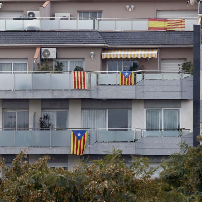 Både katalanska och spanska flaggor pryder balkonerna vid ett höghus i Barcelona.