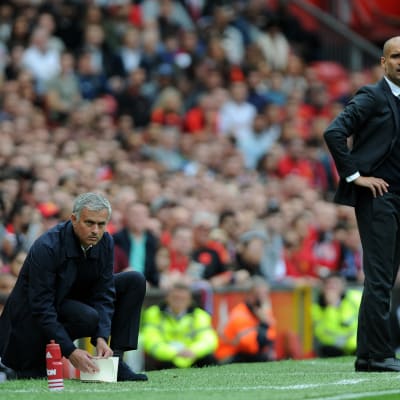 Jose Mourinho hukar ner sig bredvid tränarkollegan Pep Guardiola i Manchester-derbyt i Premier League 2016.