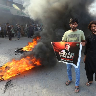 Partiaktivister och anhängare till Pakistans före detta premiärminister Imran Khan blockerar en väg. 