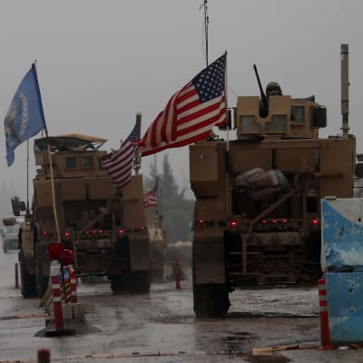 Amerikansk militärkonvoj vid vägspärr i dimmigt Syrien.