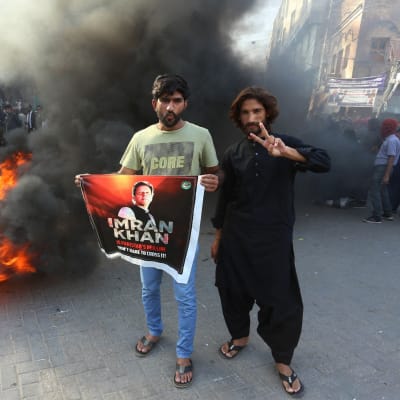 Partiaktivister och anhängare till Pakistans före detta premiärminister Imran Khan blockerar en väg. 