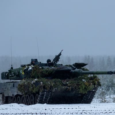 Suomen armeijan panssarivaunu etenee lumisessa maisemassa.