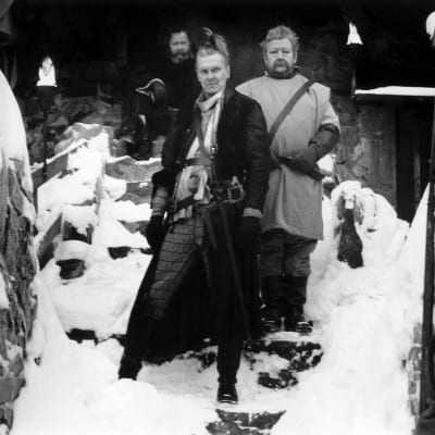 Harri Nikkonen, Paavo Piskonen ja Lasse Pöysti lumisilla linnan portailla elokuvassa Kuningas lähtee Ranskaan.