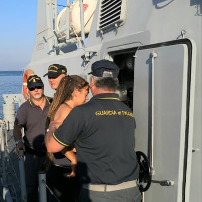 Kaptenen Carola Rackete eskorteras av polisen från Lampedusa till staden Agrigento där hon ställs inför domstol..