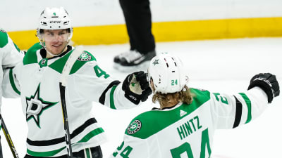 Roope Hintz och Miro Heiskanen reagerar på isen iklädda lagets vita och gröna tröjor och full ishockeymundering. 